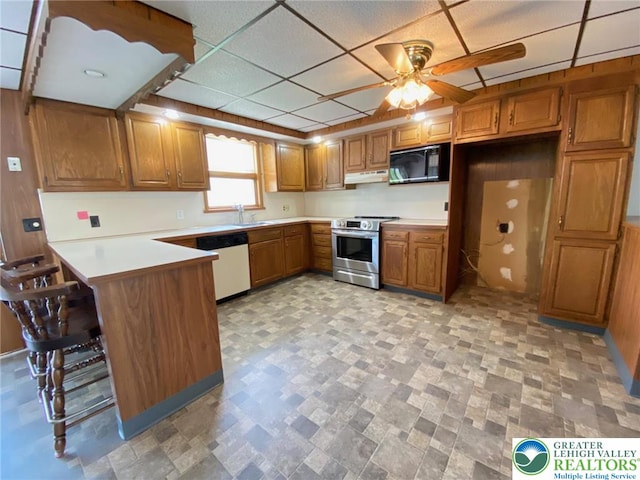 kitchen featuring a ceiling fan, white dishwasher, black microwave, brown cabinets, and stainless steel range with electric cooktop