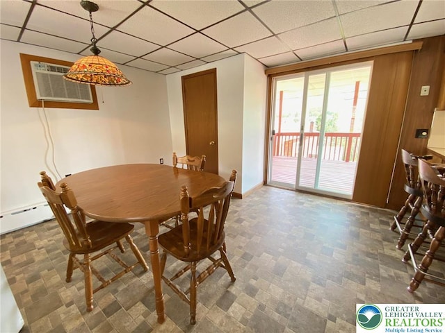 dining room with baseboards, a wall mounted air conditioner, and a paneled ceiling