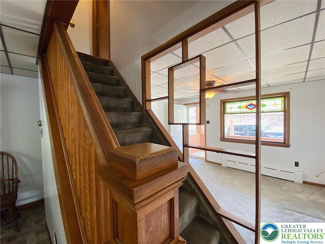 stairs featuring carpet floors, a ceiling fan, a paneled ceiling, and baseboards