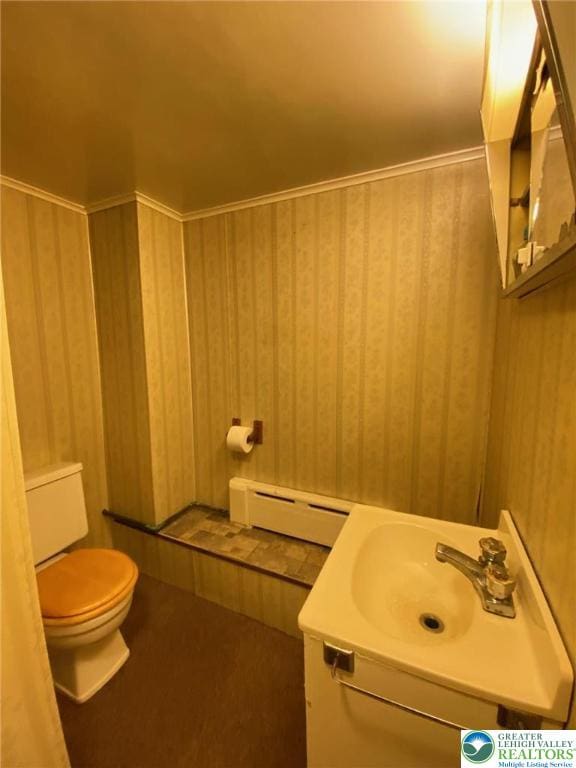 bathroom with a sink, a baseboard radiator, and toilet