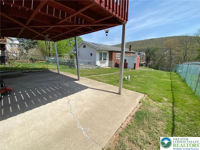 view of patio / terrace featuring fence and a carport