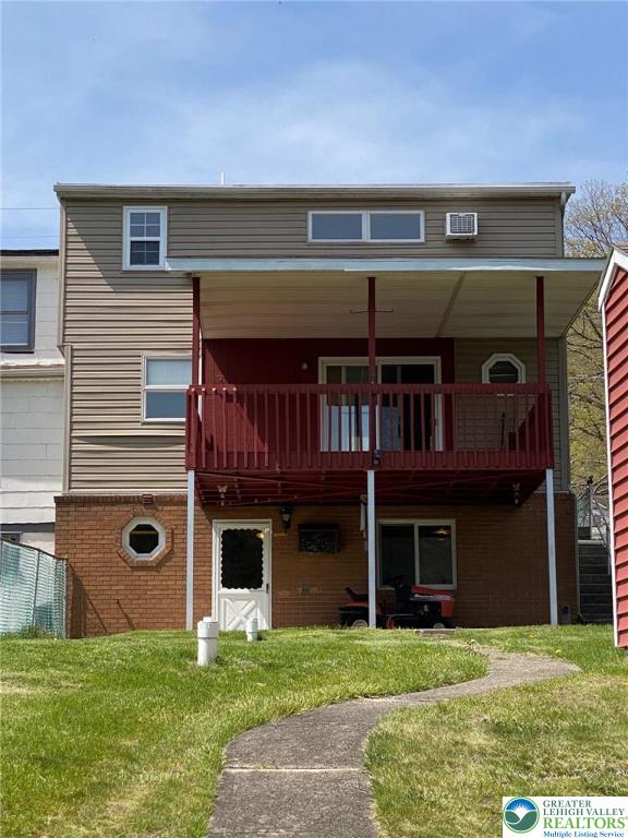 rear view of property with a lawn and brick siding