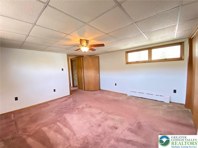 interior space with carpet floors, a drop ceiling, and baseboard heating