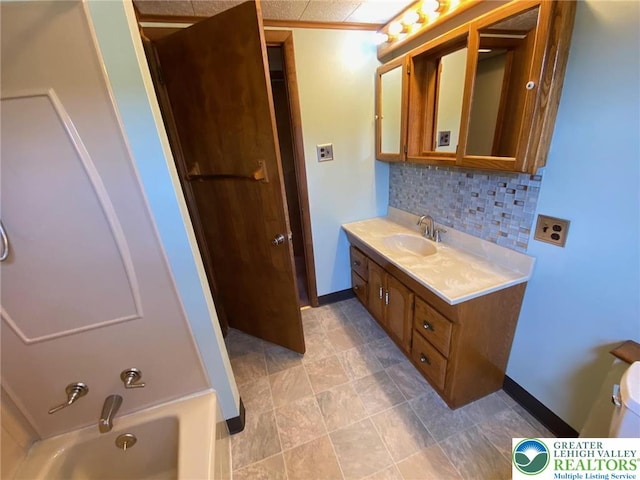 full bath featuring baseboards, decorative backsplash, a tub to relax in, and vanity