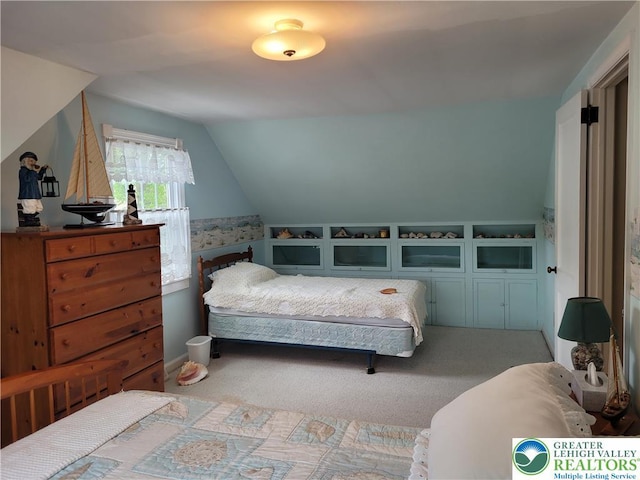 bedroom with carpet floors and vaulted ceiling