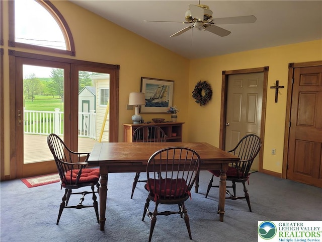 carpeted dining space featuring ceiling fan and lofted ceiling