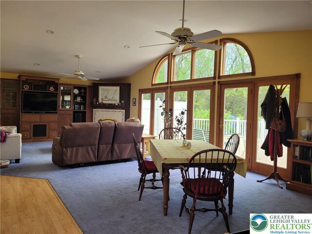 carpeted dining space featuring a ceiling fan, a wealth of natural light, and lofted ceiling
