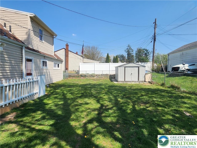 view of yard featuring an outbuilding, a shed, and a fenced backyard