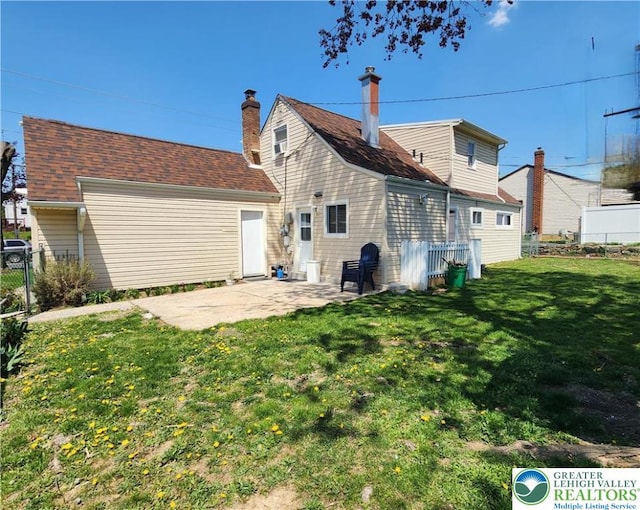 rear view of house with a patio area, fence, and a yard