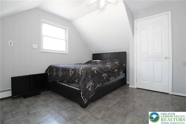 bedroom with ceiling fan, vaulted ceiling, and a baseboard heating unit
