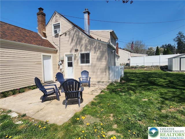 back of property with a patio area, a shed, a yard, and fence