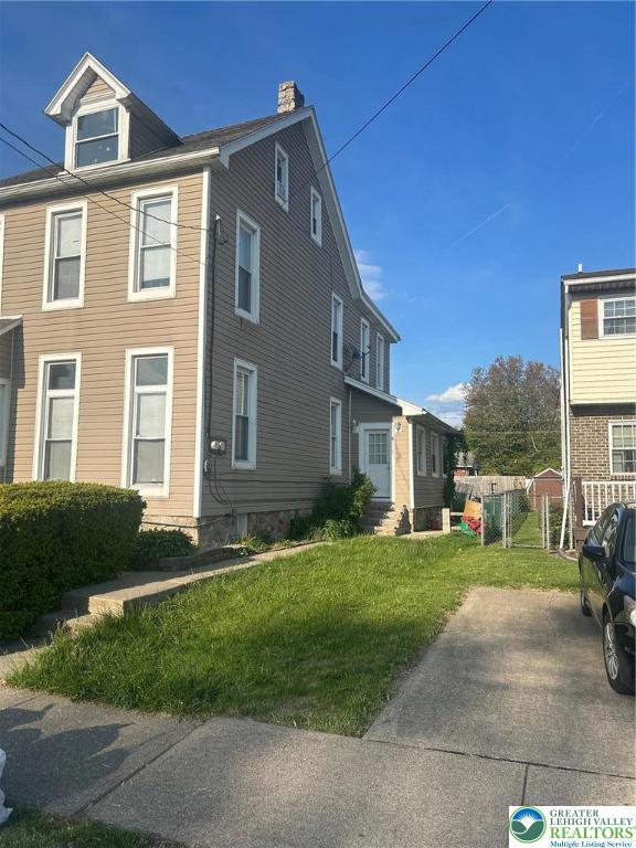 view of home's exterior with a yard and a chimney