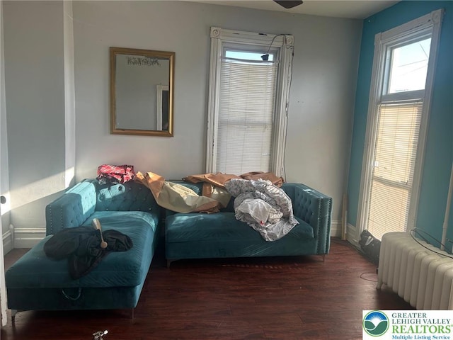 bedroom with radiator heating unit, baseboards, and wood finished floors