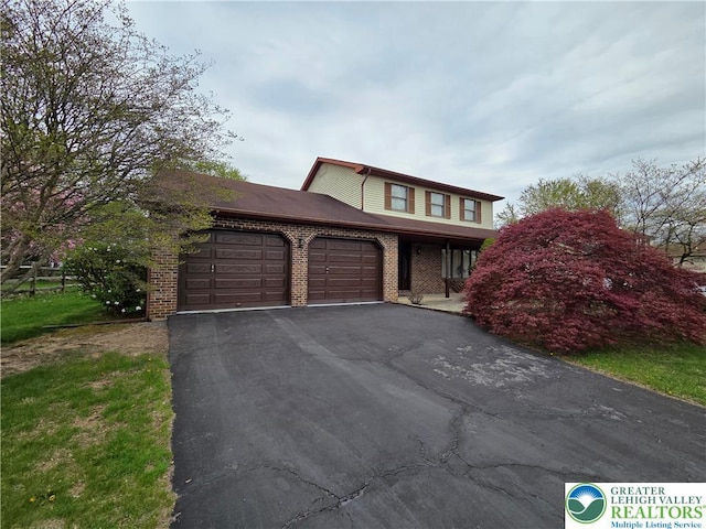 traditional home featuring brick siding, an attached garage, and driveway