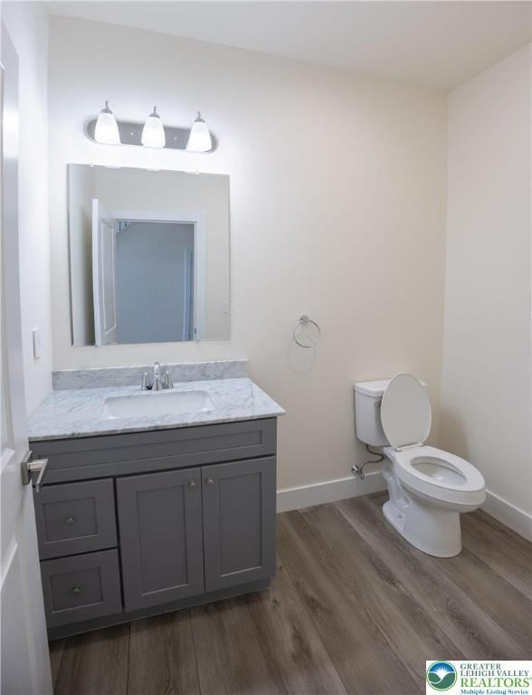 21 Piute Trl, Penn Forest Township, PA 18210 - bathroom with wood finished floors, toilet, vanity, and baseboards