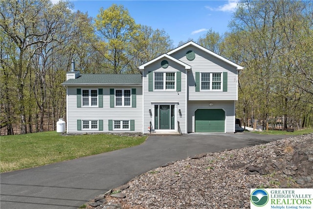 511 Lakeside Dr, Stroud Twp, PA 18301 - split level home with a chimney, an attached garage, driveway, and a front yard