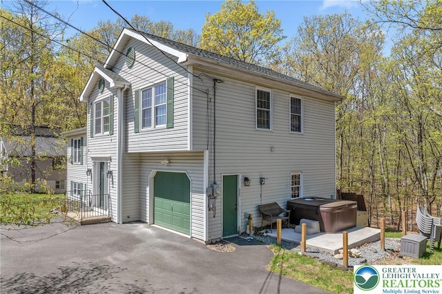511 Lakeside Dr, Stroud Twp, PA 18301 - view of home's exterior with a garage, a hot tub, and aphalt driveway