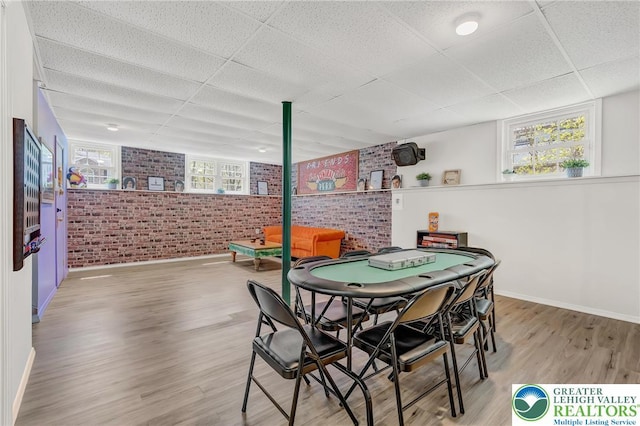 511 Lakeside Dr, Stroud Twp, PA 18301 - recreation room with brick wall, a drop ceiling, baseboards, and wood finished floors