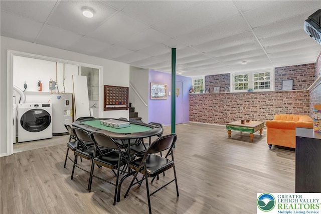 511 Lakeside Dr, Stroud Twp, PA 18301 - playroom with light wood-style floors, brick wall, a paneled ceiling, washer / clothes dryer, and electric water heater
