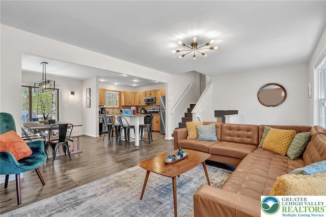 511 Lakeside Dr, Stroud Twp, PA 18301 - living area with an inviting chandelier, baseboards, light wood-style flooring, and stairs