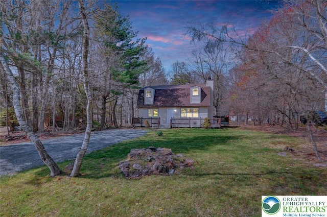 exterior space featuring a lawn, a wooden deck, and a chimney