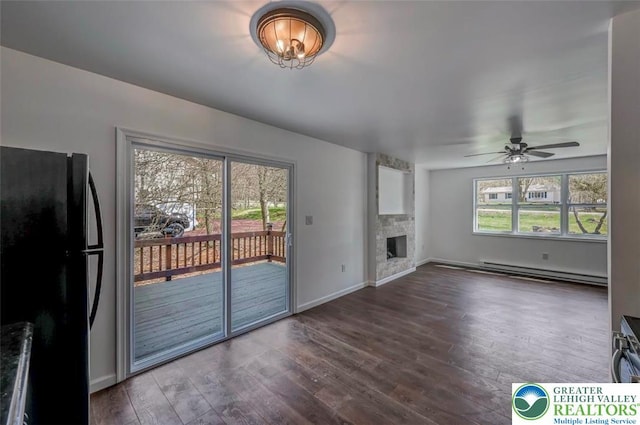 unfurnished living room with baseboards, a baseboard radiator, dark wood finished floors, and a fireplace