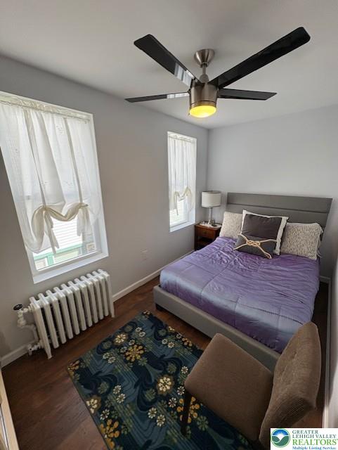 bedroom with baseboards, ceiling fan, radiator heating unit, and wood finished floors