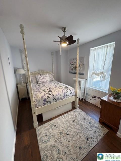 bedroom with radiator heating unit, baseboards, a ceiling fan, and dark wood-style flooring