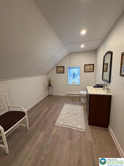 bonus room with baseboards, lofted ceiling, wood finished floors, and baseboard heating