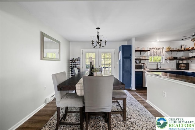 dining area with baseboards, baseboard heating, dark wood-type flooring, french doors, and ceiling fan with notable chandelier