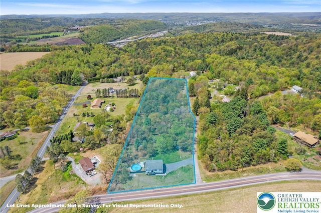 birds eye view of property with a wooded view
