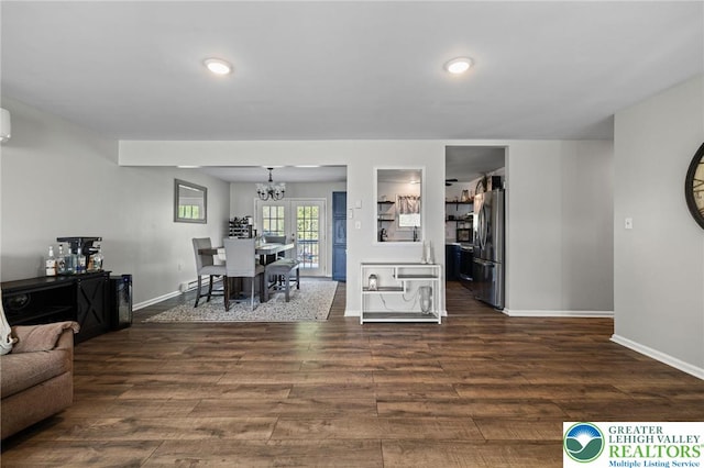 living room with recessed lighting, baseboards, an inviting chandelier, and dark wood-type flooring