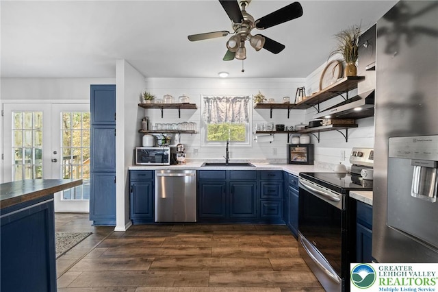 kitchen with stainless steel appliances, open shelves, a sink, and blue cabinets