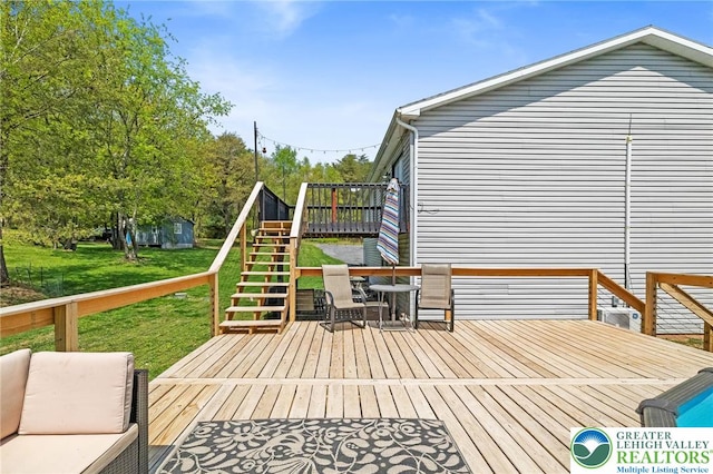 deck featuring stairs and a yard