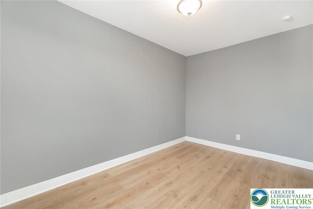 empty room featuring baseboards and light wood-type flooring