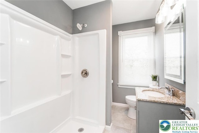 bathroom featuring vanity, toilet, tile patterned floors, baseboards, and a shower