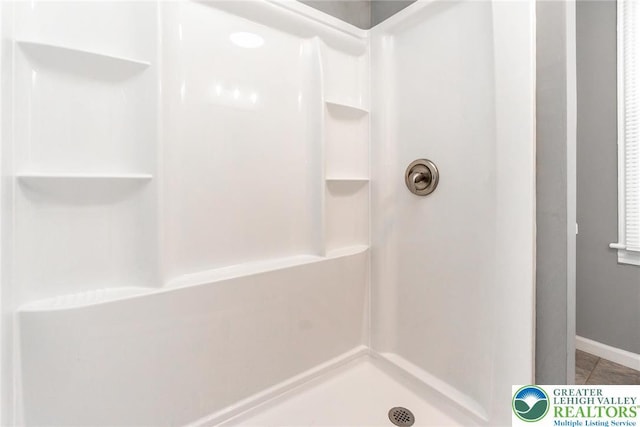 full bath with baseboards, walk in shower, and tile patterned floors