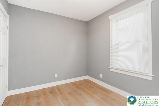 unfurnished room with baseboards and wood finished floors