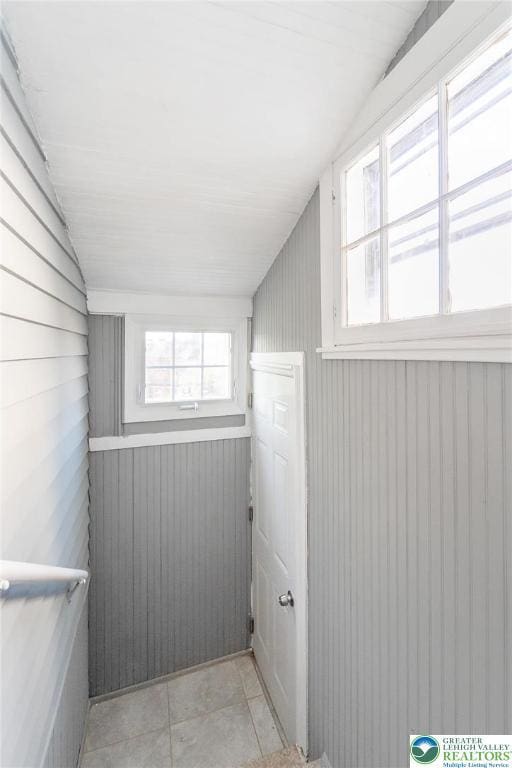 additional living space with light tile patterned floors, vaulted ceiling, and a healthy amount of sunlight