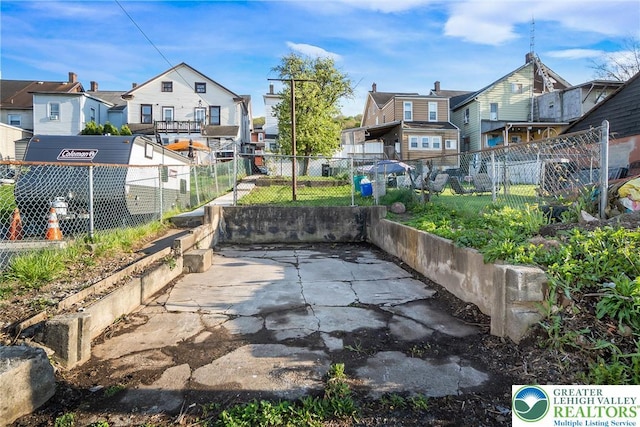 view of patio / terrace featuring fence and a residential view