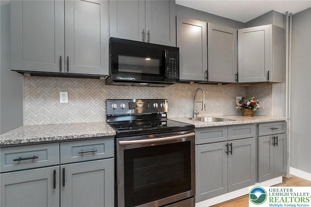 kitchen with gray cabinets, black microwave, a sink, and stainless steel electric stove