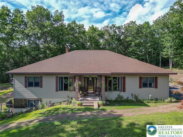 single story home featuring a porch, a shingled roof, and a front lawn