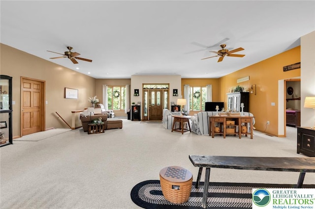 carpeted living room featuring a ceiling fan, baseboards, and plenty of natural light