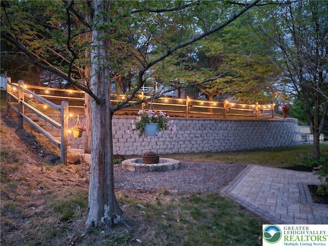 view of yard with a patio, fence, and an outdoor fire pit