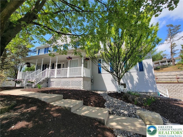 view of front of home featuring covered porch and stairs