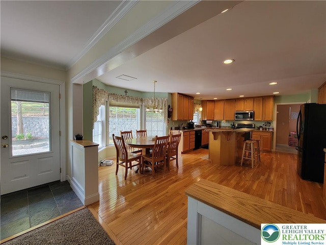 dining area with crown molding, baseboards, light wood finished floors, a chandelier, and recessed lighting