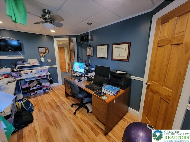 office featuring a paneled ceiling, a ceiling fan, baseboards, and light wood-style flooring
