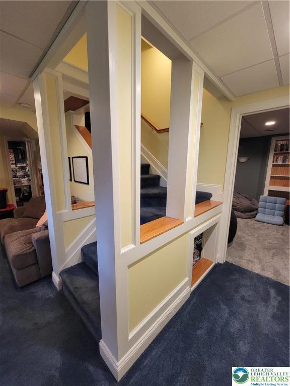 corridor featuring stairway and carpet