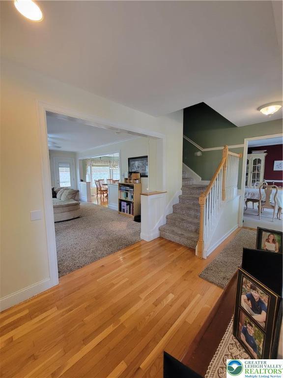 interior space with french doors, baseboards, wood finished floors, and stairway