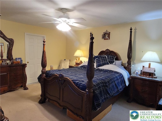bedroom with a ceiling fan and light colored carpet